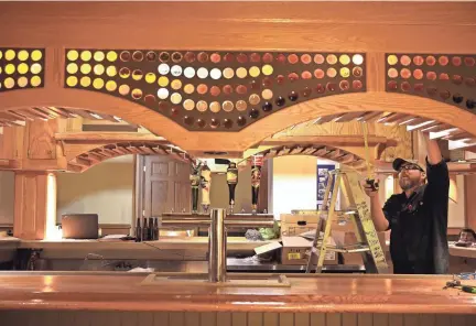  ??  ?? The Milwaukee Historical Society is making final preparatio­ns to open Brew City MKE, a brewing display with beers on tap at the former Applebee’s restaurant in The Shops of Grand Avenue. Kai Marquardt of Flowquest Design/Build builds out the bar where...