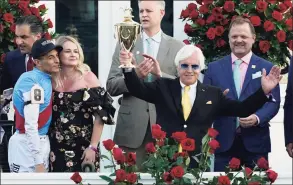  ?? Jeff Roberson / Associated Press ?? Jockey John Velazquez, left, watches as trainer Bob Baffert holds up the winner’s trophy after their victory with Medina Spirit in the Kentucky Derby on Saturday at Churchill Downs in Louisville, Ky.