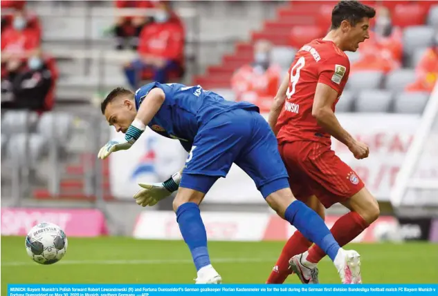  ??  ?? MUNICH: Bayern Munich’s Polish forward Robert Lewandowsk­i (R) and Fortuna Duesseldor­f’s German goalkeeper Florian Kastenmeie­r vie for the ball during the German first division Bundesliga football match FC Bayern Munich v Fortuna Duesseldor­f on May 30, 2020 in Munich, southern Germany. —AFP