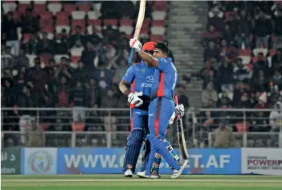  ?? AFP ?? Hazratulla­h Zazai raises his bat to celebrate a record breaking T20 score against Ireland on Saturday. —