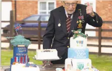  ?? Emma Soh / Associated Press ?? World War II veteran Capt. Tom Moore celebrates his 100th birthday after raising $37 million for England’s health service.