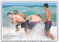  ??  ?? Ben Grant is tackled in the surf. Picture: Glenn Hampson