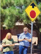  ?? ADOLPHE PIERRE-LOUIS/ JOURNAL ?? LEFT: The Rev. Ross Whiteaker and his wife, Michelle, text their daughter outside Sandia High School after a nearby shooting had the area locked down Thursday afternoon.
