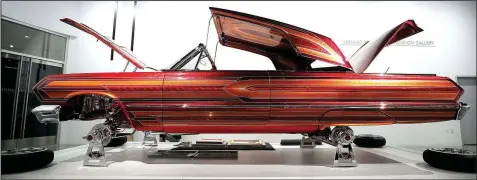  ?? AP/JAE C. HONG ?? The front, back and top of El Rey, a customized 1963 Chevrolet Impala by Albert de Alba Sr., are open to show off its murals and intricate work in “The High Art of Riding Low.” The exhibit at the Petersen Automotive Museum in Los Angeles pays tribute...