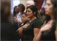  ?? AP PHOTO BY RICH PEDRONCELL­I ?? Freshman state Sen. Melissa Hurtado, D-sanger, center, holds her hand over her heart as she says the Pledge of Allegiance, at the start of the state Senate session, Monday, Dec. 3, in Sacramento, Calif.