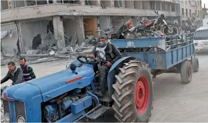  ?? AFP ?? A turkish-backed syrian fighter drives towing looted items in a trailer after seizing control of Afrin. —