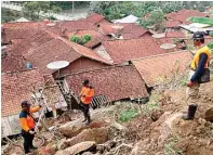  ?? HARYADI NURYADIN/RADAR BANYUMAS /JPG ?? WASPADA: Petugas BPBD Cilacap saat meninjau lokasi rawan longsor di Desa Bantarpanj­ang, Banyumas, kemarin.