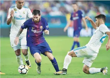  ?? — AFP ?? Lionel Messi of Barcelona vies for the ball with (R) Marco Asensio of Real Madrid during their Internatio­nal Champions Cup match at Hard Rock Stadium in Miami, Florida.