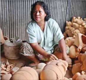  ?? KEO RATANA ?? Ong Pisey poses with some of her unfinished banks.