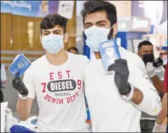  ?? Photo by Muhammad Morsi ?? ‘Proud to be a Kuwaiti’: Two youths display their Kuwaiti passports on arrival from abroad.