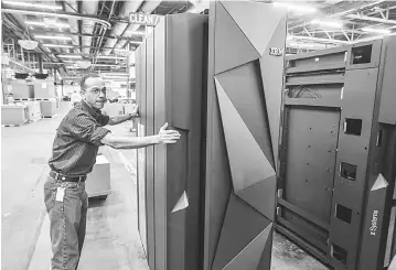  ??  ?? A worker guides the first shipment of an IBM System Z mainframe computer in Poughkeeps­ie, New York. Big US corporatio­ns have identified a new strategy for managing irate investors at annual shareholde­r meetings: Going virtual. —Reuters photo