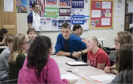  ?? JENN ACKERMAN/THE NEW YORK TIMES ?? Brent Wathke, a social studies teacher, watches his students as they discuss the election at DeLong Middle School in Eau Claire, Wis.