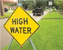  ?? American Press via Associated Press ?? n In preparatio­n of high water and flooding from Hurricane Harvey, street signs and barriers are put in places known to flood first on Friday in Lake Charles, La.