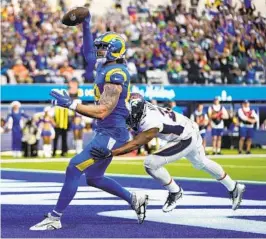  ?? JAE C. HONG AP ?? Rams tight end Tyler Higbee scores past Broncos cornerback Damarri Mathis as Los Angeles scored on every possession in 51-14 rout at SoFi Stadium on Sunday.