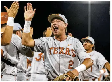  ?? CONTRIBUTE­D BY STEPHEN SPILLMAN ?? Longhorns players, including Kody Clemens (2), celebrate their 3-2 NCAA regional-clinching victory Sunday night over Indiana at UFCU Disch-Falk Field.