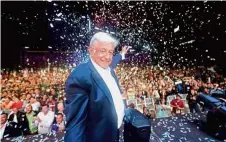  ?? — AFP ?? National jubilation: Supporters celebratin­g after Obrador’s (left) election win at Zocalo square.