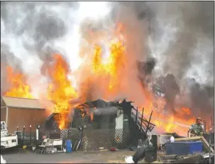  ?? The Sentinel-Record/Richard Rasmussen ?? HEAT WAVE: Members of the Lake Hamilton Fire Department fight an intense fire at 748 Red Oak Cutoff on Monday. The house reportedly contained live rounds of ammunition, which exploded during the fire.