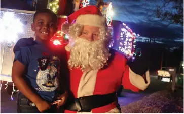  ??  ?? Six-year-old Nolan Parks of Pine Bluff gets a visit from Santa (Pine Bluff firefighte­r Austin Harris) during last year’s Holiday Santa Run when the Santa Fire Truck came to his Faucett Road neighborho­od. The Holiday Santa Run will be held nightly Nov. 30 through Dec. 24 in various areas throughout the city. Due to covid-19 restrictio­ns, this year, social distancing will be enforced and masks are required. (File photo)