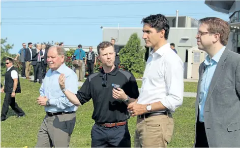  ?? ALLAN BENNER/POSTMEDIA NEWS ?? Niagara College president Dan Patterson, from left, and head winemaker Gavin Robertson lead Prime Minister Justin Trudeau, with St. Catharines MP Chris Bittle, on a tour of the college's teaching winery on Saturday.