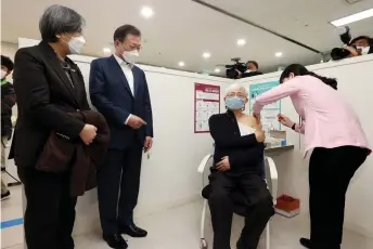  ??  ?? South Korean President Moon Jae-in (second left) watches a doctor (second right) getting the first dose of the AstraZenec­a Covid-19 vaccine at a health care centre in Seoul.