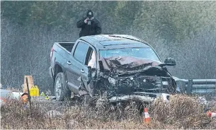  ?? FRED THORNHILL THE CANADIAN PRESS FILE PHOTO ?? An investigat­or photograph­s the bed of a crashed pickup truck at the scene of the Kawartha Lakes OPP shooting in November that left an 18-month-old male child and his father dead.