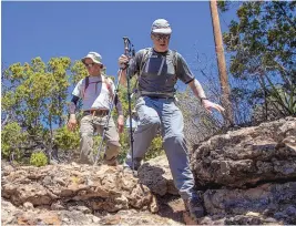  ?? ?? Gustaaf Van Moorsel, right, descends a rocky trail during a hike to Cedro Peak in April.