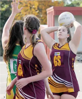  ??  ?? Drouin goal shooter Abbey Tyrell takes aim against Leongatha in B grade on Saturday as teammate Taylah Marsh-Irwin blocks out for any rebound.