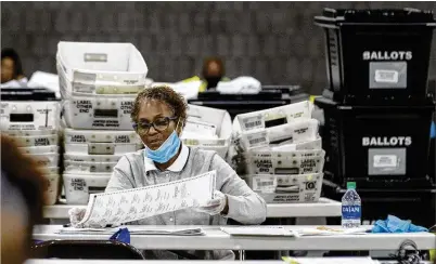  ?? ALYSSA POINTER / ALYSSA.POINTER@AJC.COM ?? Fulton County employees continue to count mailed absentee ballots Wednesday at the Georgia World Congress Center in Atlanta. Final vote tallies from Tuesday’s election aren’t expected until Friday, officials said.