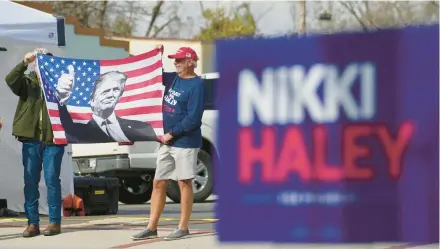  ?? RUTH FREMSON/THE NEW YORK TIMES ?? Donald Trump supporters hold up a flag Friday outside a campaign event for Nikki Haley in Moncks Corner, South Carolina.