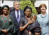  ?? (AP/J. Scott Applewhite) ?? Then-President George W. Bush and Laura Bush pose with mothers affected by AIDS and their HIV-free children in Abuja, Nigeria, in July 2003.