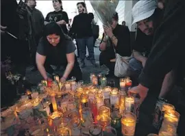  ?? Luis Sinco Los Angeles Times ?? MOURNERS in L.A. pay respects to victims of Sunday’s tour bus crash on I-10 that killed 13 and hurt 31. Investigat­ors say the bus had worn tires. CALIFORNIA, B1