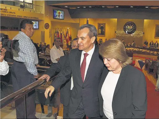  ??  ?? Le quitan inmunidad. El embajador José Atilio Benítez Parada, junto a su esposa, se retiran de la Asamblea Legislativ­a luego de quitarle el fuero.