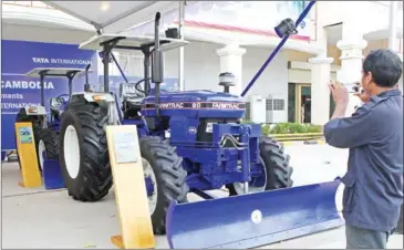  ?? PHA LINA ?? A man takes a photo of an Indian-made Tata tractor on display in Phnom Penh in 2013.