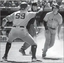  ?? FRED THORNHILL/THE CANADIAN PRESS VIA AP ?? Aaron Judge (99), greets Tyler Wade, who scored the go-ahead run in the 10th inning to give the Yankees a 2-1 win over Toronto on Sunday.