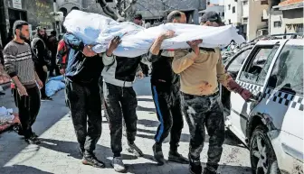  ?? [AFP ] ?? In Gaza City werden die Todesopfer einer Massenpani­k zu Grabe getragen.