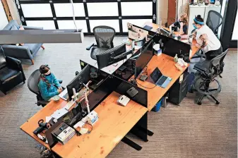  ?? LEAH NASH/THE NEW YORK TIMES ?? Lilly, left, and Dylan Taylor attend remote school Sept. 8 at their mother’s empty office at Kinesis in Portland, Oregon.