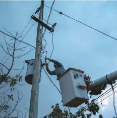  ?? AP ?? A man works to restore power in Adjuntas, Puerto Rico. The US territory’s electrical grid is still shaky after Hurricane Irma hit the island as a Category 5 storm last year in September.