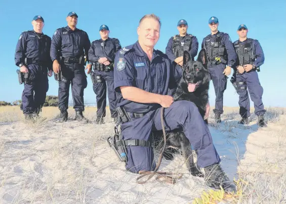  ?? Picture: MIKE BATTERHAM ?? Retiring Dog Squad officer Wayne Algie with his police dog Rex and team members (from left) Clint Thomasson, Joseph Alofipo, Ben Miles, Lyle Slingsby, Sam Mosey and Nick Donald in the dunes at Main Beach.