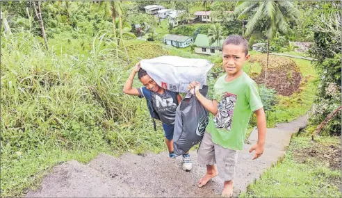  ?? Picture: SOPHIE RALULU ?? Keni Raione (left) with his brother Viliame Tamanikait­ani of Naisogowal­uvu settlement carry their stuff up the 200 steps to the main road at Delainaves­i.