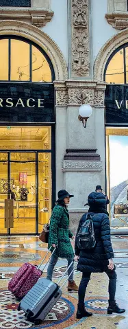  ??  ?? In Galleria Due turiste con i trolley nel Salotto del centro storico di Milano (foto Ansa)