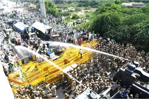  ?? — AFP photo ?? New Delhi police use water canons to disperse and stop protesting farmers at the border with Ghazipur during their march to New Delhi.