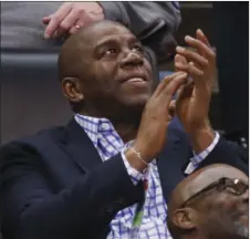  ??  ?? Magic Johnson, president of basketball operations for the Los Angeles Lakers, applauds as he watches the kiss cam on the scoreboard during the third quarter of an NBA basketball game between the Lakers and the Oklahoma City Thunder in Oklahoma City on...