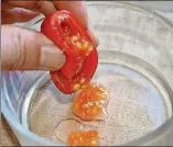 ?? LEE REICH/ASSOCIATED PRESS 2013 ?? The first step in saving tomato seeds entails nothing much more than squeezing a bit of the seed-gel mix out of the cavity of a tomato fruit into a glass. No need even to sacrifice eating the rest of the fruit.
