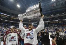  ?? PHELAN EBENHACK /AP ?? Colorado Avalanche center Nathan MacKinnon lifts the Stanley
Cup after the team defeated the Tampa
Bay Lightning in game 6 on Sunday in Tampa, Fla.