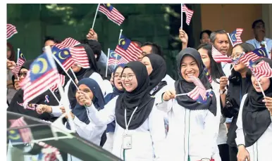  ??  ?? In the spirit of Merdeka: PLUS employees cheering and waving the Jalur Gemilang in support of the PLUS Unity Drive at Persada PLUS in Subang Jaya.