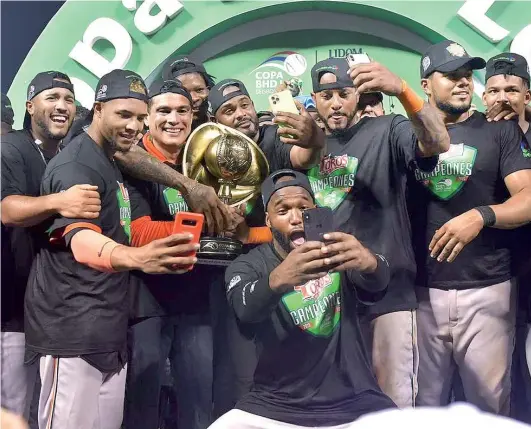  ?? CORTESÍA VÍCTOR CALVO ?? Jugadores de los Toros celebran anoche mientras sostienen el trofeo de campeones.