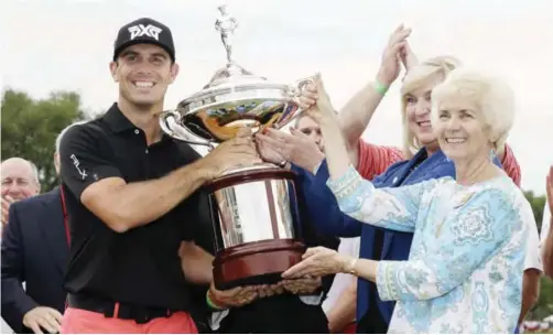  ?? — AP ?? TEXAS: Billy Horschel is awarded the tournament trophy by Peggy Nelson, widow of Byron Nelson after Horschel’s win in the Byron Nelson golf tournament on Sunday, May 21, 2017.