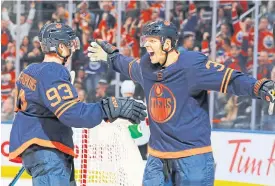  ??  ?? Oilers forward Alex Chiasson, right, celebrates his third-period goal against the Devils with Ryan Nugent-Hopkins.