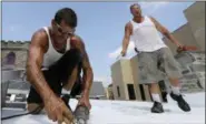  ?? DAVID SWANSON/THE PHILADELPH­IA INQUIRER VIA AP ?? Roofers Ricky Yarnall, left, and Mike Oakes are convinced it is 40 degrees hotter on the top of the Central Baptist Church in Wayne, as they work through Wednesday afternoon, Aug. 29.