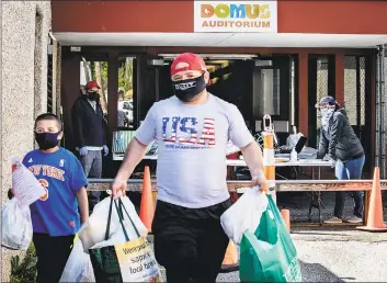  ?? Conn. Health I-Team ?? A man and boy leave the Domus Person to Person food pantry on Lockwood Avenue, Stamford.